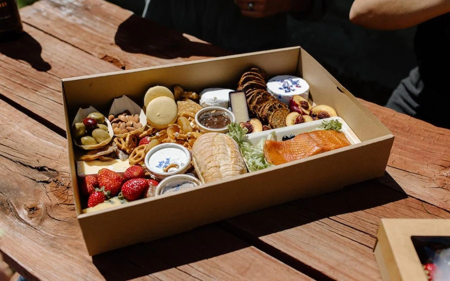 A picnic set out on a grassy shelf below a glacier with no road in sight