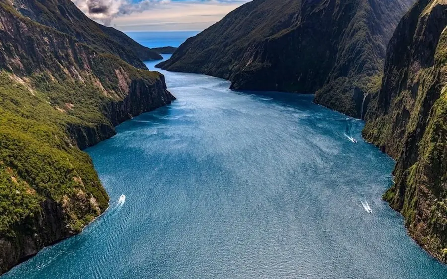 Alpine lakes and a remote valley below snow peaks seen from the air