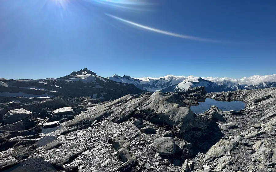 Glacial icefalls and native forest below the snow line seen from a helicopter